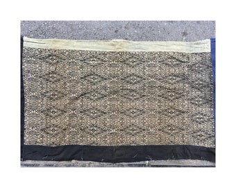 May include: A black and white woven fabric with a geometric pattern. The fabric has a beige background with black diamond shapes.