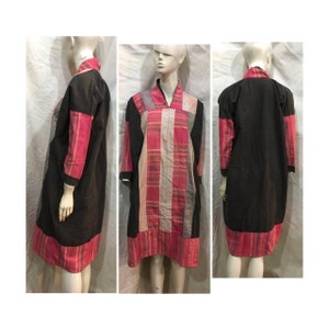 May include: A long, black and pink dress with a checkered pattern. The dress has a V-neck and long sleeves.