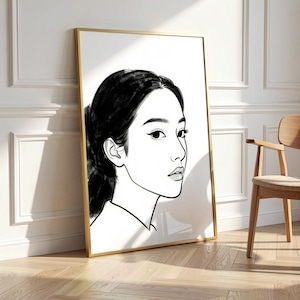 Könnte beinhalten: Ein gerahmter Kunstdruck mit einer Schwarz-Weiß-Illustration des Gesichts einer Frau im Profil. Das Kunstwerk ist minimalistisch, mit kräftigen Linien, die die Merkmale definieren. Der Rahmen ist goldfarben.
