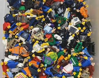 May include: A collection of colorful Lego minifigure torsos, featuring a variety of designs and colors. The torsos are in various colors, including red, blue, black, white, and orange, with printed details. The minifigures are scattered in a pile.
