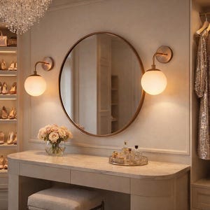 May include: A dressing room with a vanity, round mirror, and built-in shoe storage. The vanity has a marble top and a small stool. A closet with hanging clothes is on the right. The room is decorated in neutral tones with a chandelier.