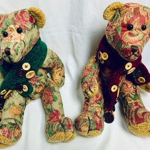 May include: Two plush teddy bears with floral patterned fabric. One bear has a green scarf and the other has a burgundy scarf. Both bears have button accents.