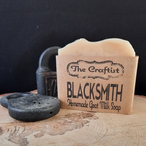 May include: A bar of goat milk soap in a brown paper wrapper with the text "The Craftist" and "BLACKSMITH Homemade Goat Milk Soap".