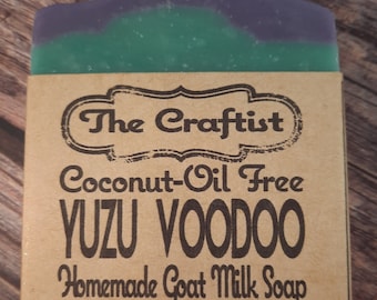 Könnte beinhalten: Eine handgemachte Ziegenmilchseife mit einem violetten und grünen Wirbelmuster. Die Seife ist mit "The Craftist Coconut-Oil Free Yuzu Voodoo Homemade Goat Milk Soap" beschriftet.