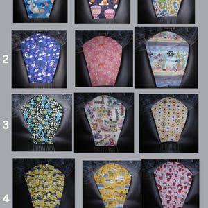 K&ouml;nnte beinhalten: Ein Raster aus zw&ouml;lf Stoffabdeckungen mit verschiedenen Mustern, darunter Hei&szlig;luftballons, Dinosaurier, Meerestiere, Blumen, Zeichentrickfiguren und Baufahrzeuge. Jede Abdeckung hat eine konische Form mit einer Metallschlaufe.