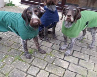 Um suéter de lã para cães com uma única camada de lã e cinto de lã está disponível em tamanhos que variam de 19" a 26".