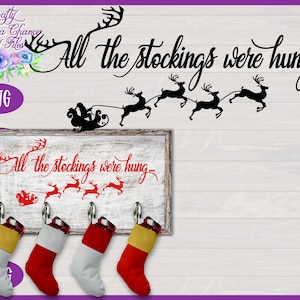 Op de afbeelding: Een wit houten bord met de tekst "All the stockings were hung..." in rode cursieve letters.  Er hangen vier rood-witte kousen aan haken onder het bord.  Het bord is versierd met een rood silhouet van Sinterklaas in een slee getrokken door rendieren.