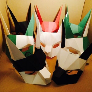 May include: Five paper masks in various colors, including black, white, green, and red. The masks are all different shapes and sizes, and they have a variety of features, such as ears, noses, and mouths.