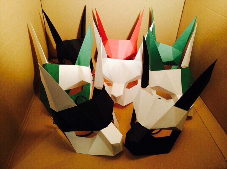 May include: Five paper masks in various colors, including black, white, green, and red. The masks are all different shapes and sizes, and they have a variety of features, such as ears, noses, and mouths.