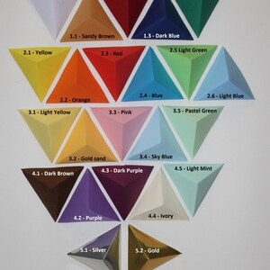 May include: A chart of 25 different colors, each represented by a triangular paper shape. The colors are labeled with numbers and names, such as 0 - White, 1.1 - Sandy Brown, 2.1 - Yellow, 2.2 - Orange, 3.1 - Light Yellow, 3.2 - Gold sand, 4.1 - Dark Brown, 4.2 - Purple, 5.1 - Silver, 5.2 - Gold, 1.2 - Dark Red, 1.3 - Dark Blue, 1.4 - Dark Green, 2.3 - Red, 2.4 - Blue, 2.5 Light Green, 2.6 - Light Blue, 3.3 - Pink, 3.4 - Sky Blue, 3.5 - Pastel Green, 4.3 - Dark Purple, 4.4 - Ivory, 4.5 - Light Mint.