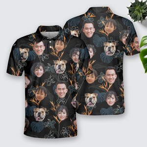 May include: A black polo shirt with a floral pattern featuring multiple faces and a dog. The shirt has a collar and short sleeves.