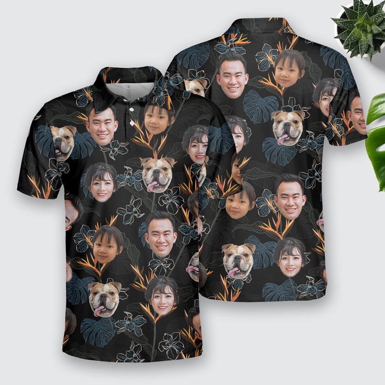 May include: A black polo shirt with a floral pattern featuring multiple faces and a dog. The shirt has a collar and short sleeves.
