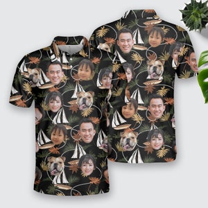 May include: A black short-sleeved button-down shirt with a tropical print featuring faces of people and dogs. The print is repeated throughout the shirt.