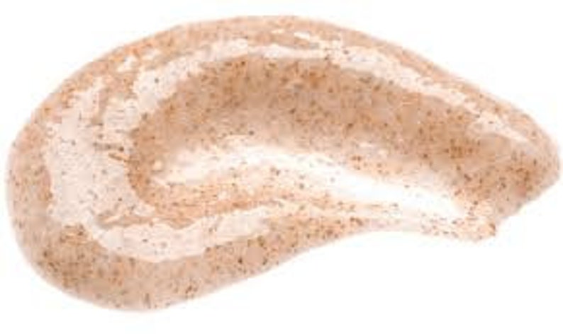 May include: Close-up of a light brown scrub with small exfoliating particles. The scrub has a smooth, gel-like consistency.