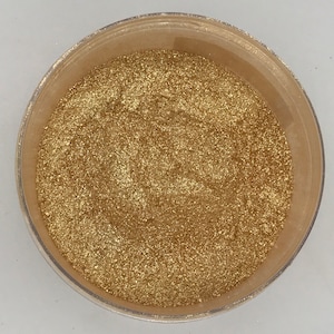 May include: A small container filled with gold glitter.