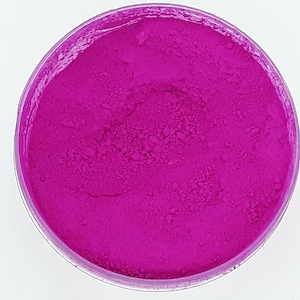 Puede incluir: Un pequeño recipiente redondo lleno de un polvo rosa brillante y vibrante. El polvo está finamente molido y tiene una textura suave y uniforme.