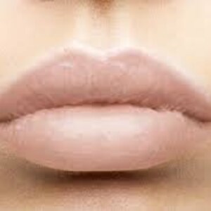 May include: Close-up of nude-coloured lips with a glossy finish.