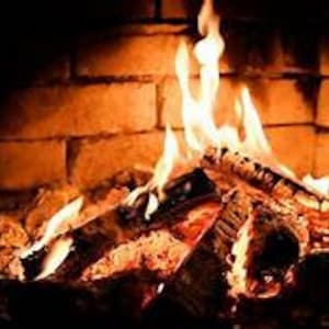 May include: A brick fireplace with a roaring fire. The flames are orange and yellow, and the logs are burning brightly.