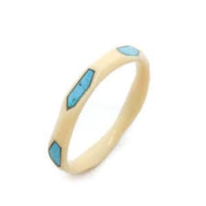May include: A white bone bangle with a wavy design and blue turquoise accents.