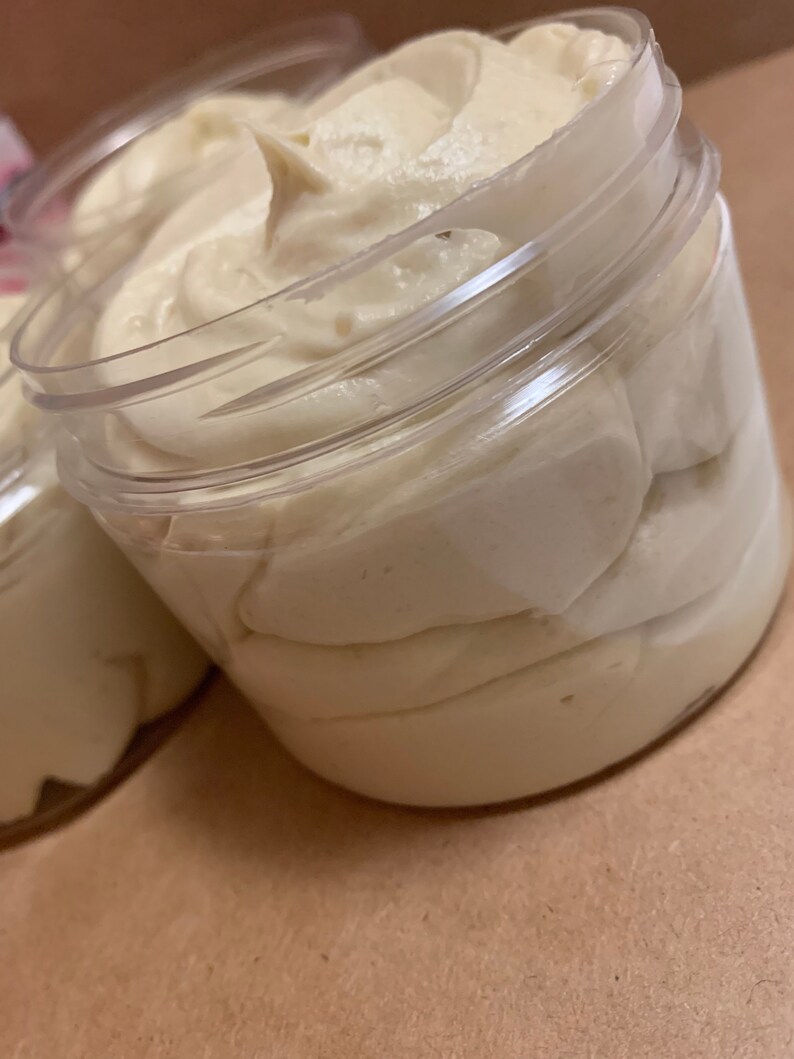 May include: A clear plastic jar filled with a thick, white cream. The cream is smooth and has a slightly textured surface.