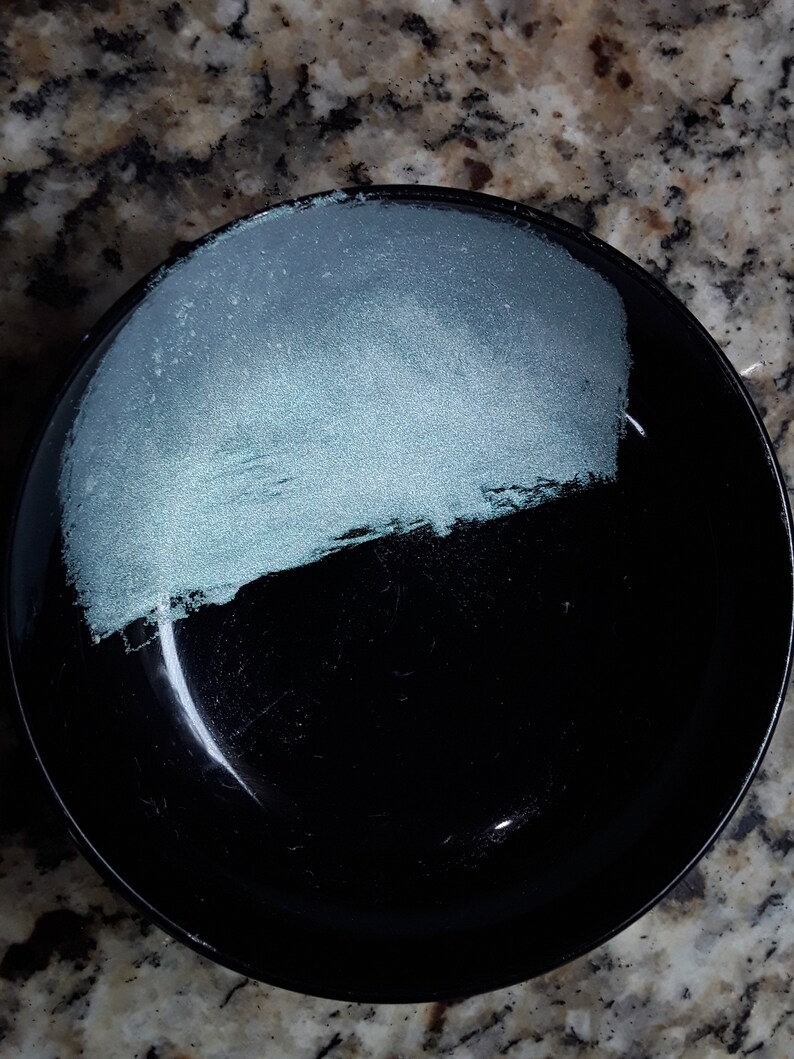 K&ouml;nnte beinhalten: Eine schwarze Sch&uuml;ssel mit einer hellblauen Glasur auf der oberen H&auml;lfte. Die Sch&uuml;ssel ist rund und hat eine glatte Oberfl&auml;che.