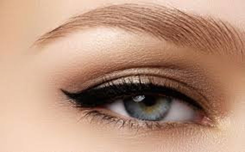 May include: Close-up of a woman's eye with a winged black eyeliner look and neutral eyeshadow.