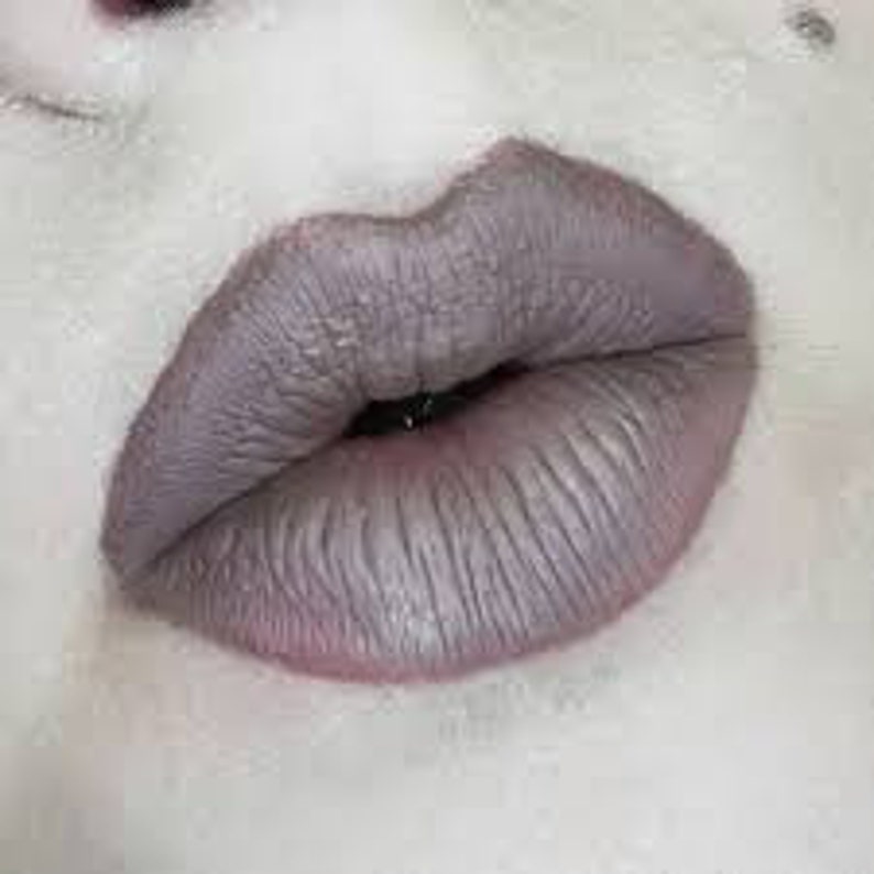 Puede incluir: Primer plano de los labios de una persona con un labial mate gris claro.