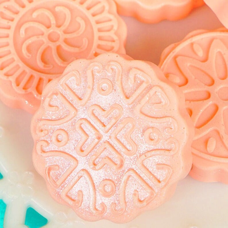 Peut inclure: Gros plan sur quatre bombes de bain roses et blanches avec des motifs d&eacute;coratifs. Les bombes de bain sont rondes et ont une surface lisse et brillante.