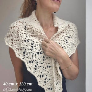 May include: A white crocheted shawl with a delicate lace pattern. The shawl measures 40 cm by 120 cm. The text "Tasha Be Spoke" is visible in the bottom left corner of the image.