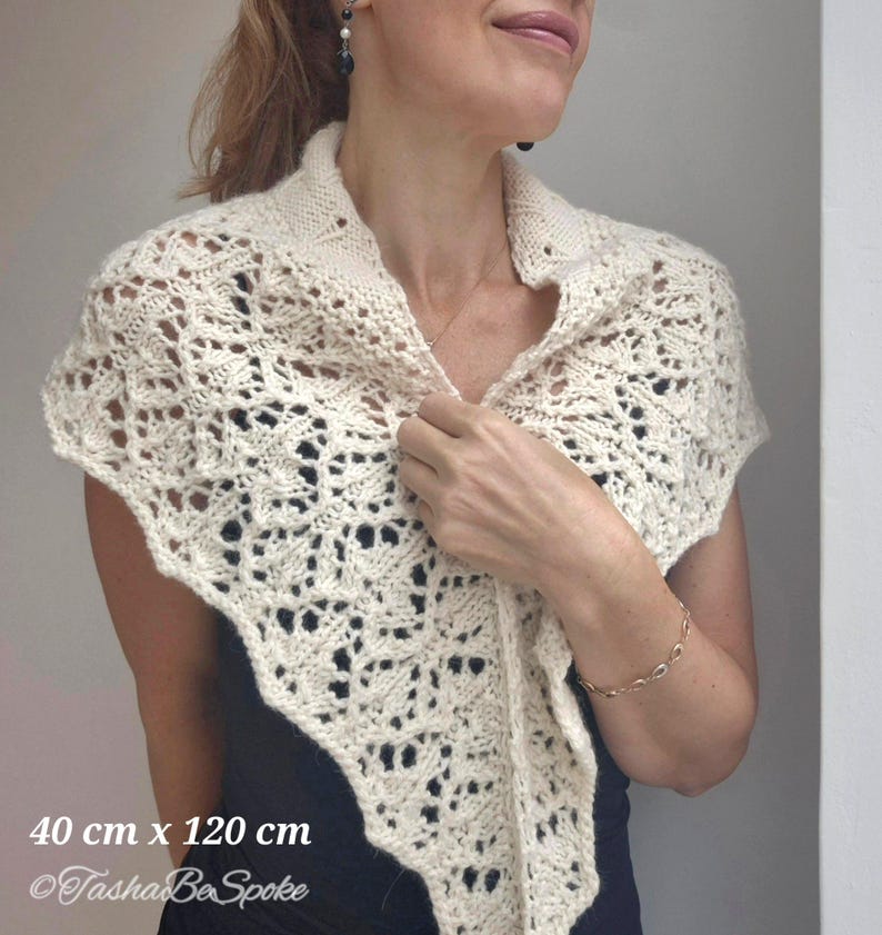 May include: A white crocheted shawl with a delicate lace pattern. The shawl measures 40 cm by 120 cm. The text "Tasha Be Spoke" is visible in the bottom left corner of the image.