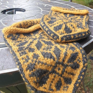 May include: A pair of knitted slippers in a black and mustard yellow geometric pattern. The slippers are made with a thick yarn and have a soft, cozy feel.