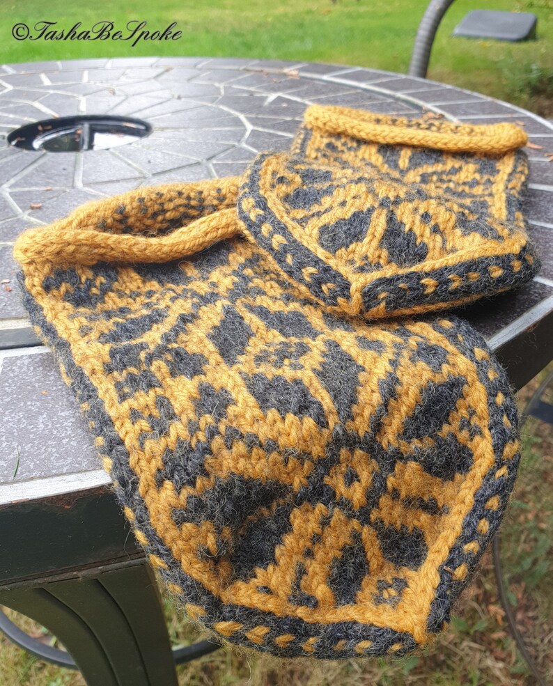 May include: A pair of knitted slippers in a black and mustard yellow geometric pattern. The slippers are made with a thick yarn and have a soft, cozy feel.
