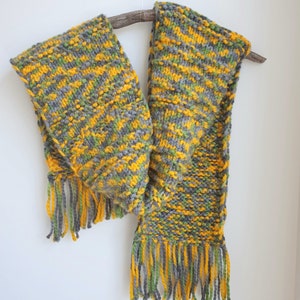 May include: A hand-knitted scarf in shades of yellow, green, and gray with fringe on the ends.