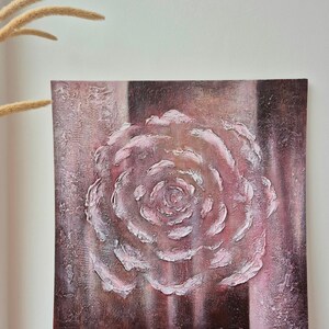 May include: A square canvas artwork depicting a textured rose in shades of pink and white, set against a textured, dark burgundy backdrop. The artist's signature, "TashaBeSpoke", is visible. The piece is a floral-themed artwork.