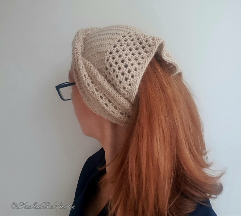 Puede incluir: Una diadema de crochet beige con un patr&oacute;n de encaje. La diadema la lleva una persona con el pelo largo y rojo.