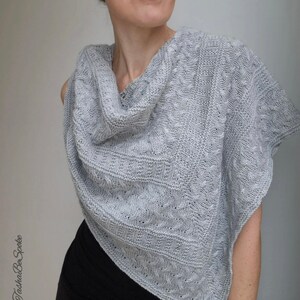 May include: A gray knitted shawl with a cowl neck and a cable knit pattern.