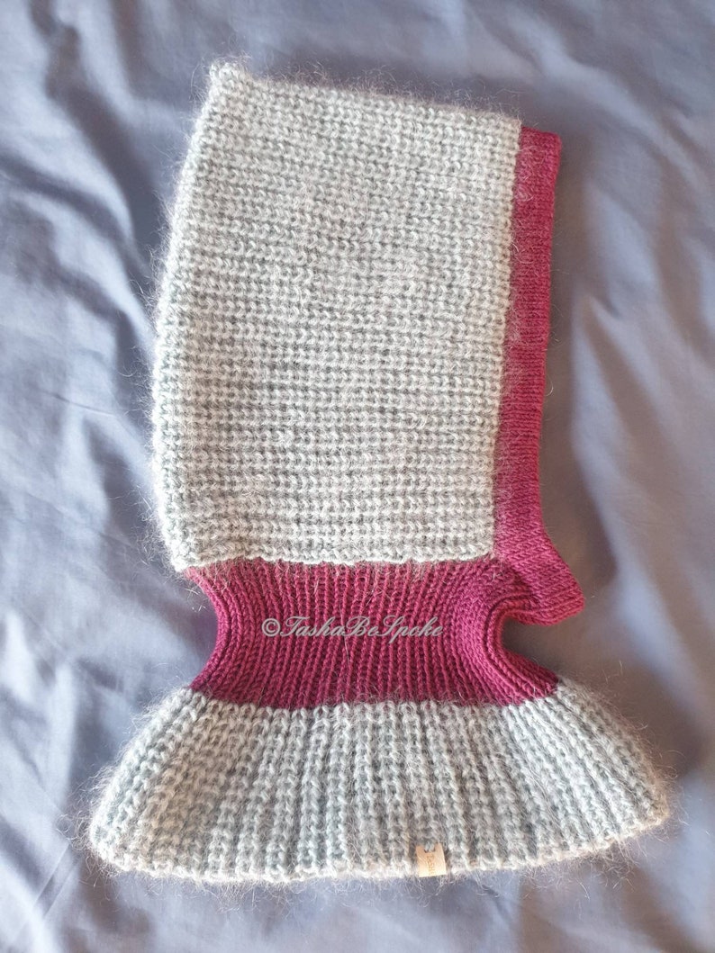 Pu&ograve; includere: Un passamontagna lavorato a maglia grigio e bordeaux. Il passamontagna presenta un fondo a coste, una sezione centrale bordeaux e una parte superiore grigia. I bordi sono rifiniti in bordeaux. Il passamontagna &egrave; realizzato con un filato morbido e soffice.