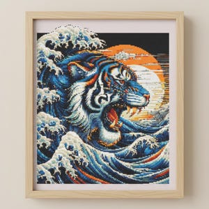 May include: Framed art print depicting a pixelated tiger amidst ocean waves. The tiger, with blue and orange stripes, is set against a rising sun. The waves are in shades of blue and white, within a wooden frame.