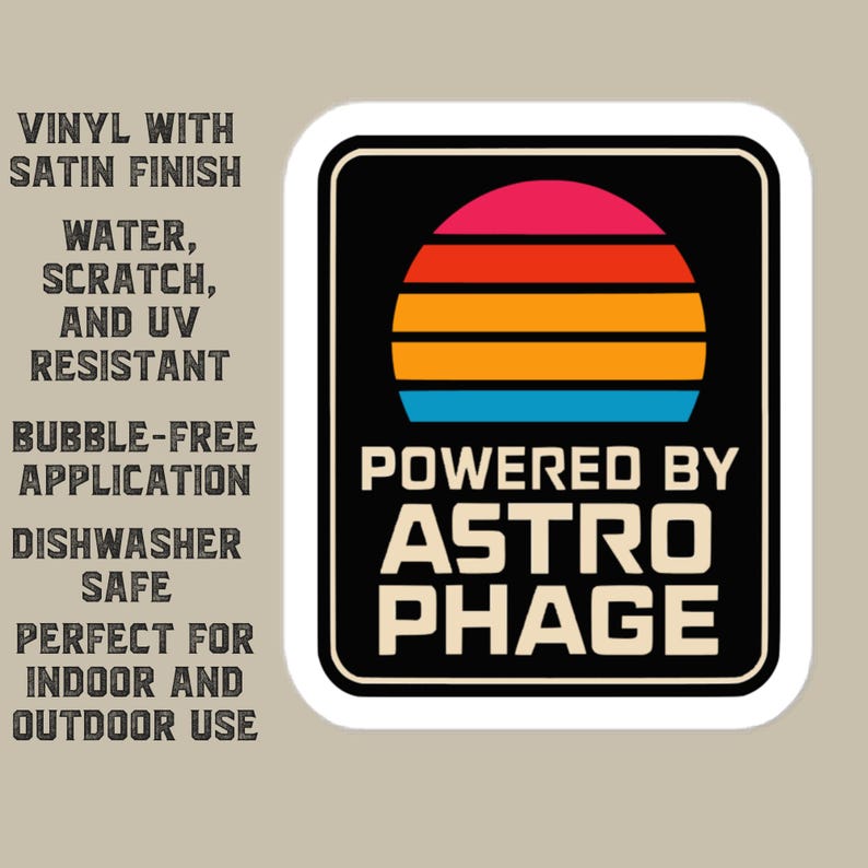 May include: A rectangular vinyl sticker with a black background featuring a stylized sunset graphic in pink, red, orange, and blue stripes above the text POWERED BY ASTRO PHAGE in white. The text to the left lists product features including vinyl with satin finish, water, scratch, and UV resistant, bubble-free application, dishwasher safe, and indoor and outdoor use.