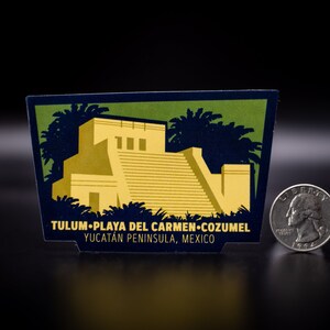 May include: A blue and green sticker with a yellow illustration of a Mayan pyramid and palm trees. The sticker reads "Tulum-Playa del Carmen-Cozumel Yucatan Peninsula, Mexico".