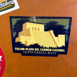 May include: A green, yellow, and blue sticker with a stylized image of a Mayan temple with a text overlay that reads "TULUM.PLAYA DEL CARMEN.COZUMEL YUCATAN PENINSULA, MEXICO"