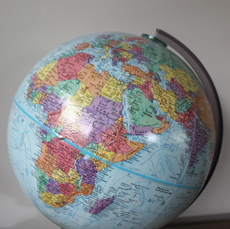 May include: A colorful, detailed globe with a blue ocean and multi-colored continents. The globe is mounted on a dark gray stand and features country names and borders. A classic educational tool.