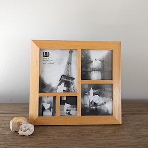 May include: A light brown wooden multi-photo frame with four openings, holding black and white photos. The frame has the text "Umbra loft" and holds two 4" x 6" and two 2" x 2" photos. Two small, white, geode stones sit in front of the frame.