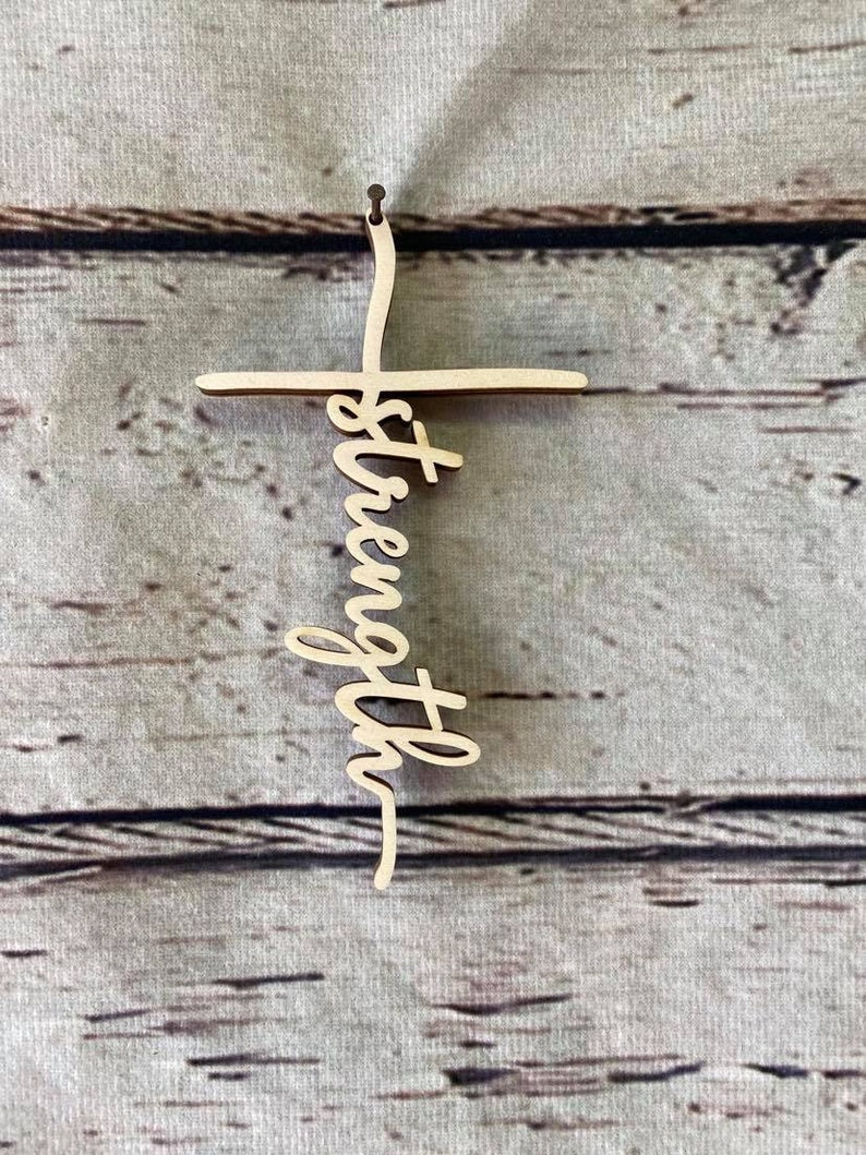 K&ouml;nnte beinhalten: Holzkreuz mit dem Wort "St&auml;rke" vertikal in der Mitte geschrieben.