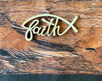 May include: A wooden cutout of a fish with the word "faith" written inside. The cutout is a light brown color and has a hole at the top for hanging.