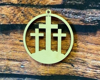 May include: A light beige wooden ornament with three cutout crosses. The ornament is round and has a hole at the top for hanging.