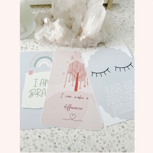 Puede incluir: Tres tarjetas de afirmaci&oacute;n con fondos pastel e ilustraciones coloridas. La primera tarjeta dice "Soy valiente". La segunda tarjeta dice "Puedo marcar la diferencia". La tercera tarjeta dice "Soy una persona incre&iacute;ble".