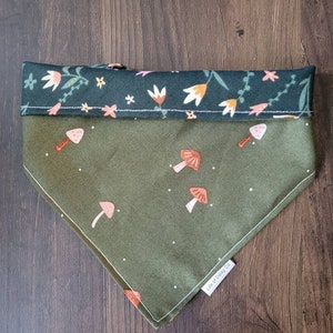 May include: Green bandana with a white polka dot pattern and a mushroom print. The bandana has a dark green floral print border and the text "Life of Daisy Co."