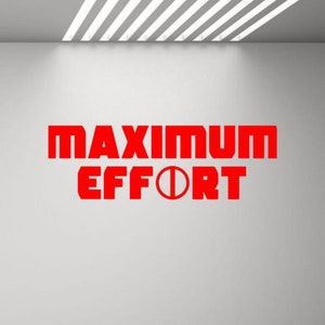 Może przedstawiać: Czerwony tekst na białej ścianie głosi "MAXIMUM EFFORT" z kółkiem w środku słowa "EFFORT".