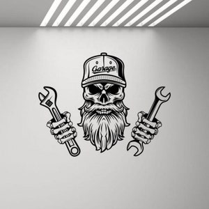 May include: Black and white graphic of a skull wearing a cap that says "Garage" and holding two wrenches. The skull has a long beard and mustache, with the wrenches held in skeletal hands.
